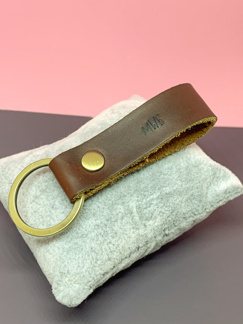 personalized leather key chain in hand on cushion